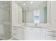Modern bathroom featuring double sinks, sleek white cabinetry, and a glass-enclosed shower at 100 1St N Ave # 2304, St Petersburg, FL 33701