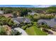 A beautiful aerial view of the property featuring lush landscaping, mature trees, and a long driveway at 1000 Chatham Ct, Safety Harbor, FL 34695