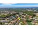 Aerial view of a neighborhood with ponds and mature trees with a glimpse of the ocean at 1000 Chatham Ct, Safety Harbor, FL 34695