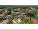 Bird's eye view of the property, highlighting its location near lush trees, a serene lake, and surrounding residences at 1000 Chatham Ct, Safety Harbor, FL 34695