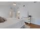 Bright bedroom boasts a vaulted ceiling, ceiling fan and white dresser with view into en suite bath at 1000 Chatham Ct, Safety Harbor, FL 34695