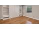 Bedroom features sleek hardwood floors, built-in shelves and storage with natural light from the window at 1000 Chatham Ct, Safety Harbor, FL 34695