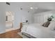 Bright bedroom features a white dresser, hardwood floors and views into the en suite bathroom at 1000 Chatham Ct, Safety Harbor, FL 34695