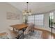 Bright dining room with wood table, modern light fixture, and elegant decor and large window at 1000 Chatham Ct, Safety Harbor, FL 34695