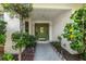 Inviting home entrance featuring a decorative green door, lush landscaping, and a paved walkway at 1000 Chatham Ct, Safety Harbor, FL 34695