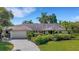 Charming single-story home featuring a lush landscaped front yard and a spacious two-car garage at 1000 Chatham Ct, Safety Harbor, FL 34695