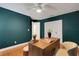 Stylish home office features teal walls, modern desk, bench and gleaming hardwood floors at 1000 Chatham Ct, Safety Harbor, FL 34695