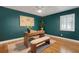 Stylish home office with teal walls, modern desk, bench and beautiful hardwood floors at 1000 Chatham Ct, Safety Harbor, FL 34695
