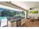 Outdoor kitchen equipped with a sink, cooktop, and bar area, perfect for poolside entertaining at 1000 Chatham Ct, Safety Harbor, FL 34695
