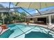 Enjoy the outdoor living space with the sparkling screened-in pool, patio area, grill, and tranquil backyard at 1000 Chatham Ct, Safety Harbor, FL 34695