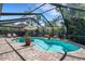 Enjoy the screened-in pool area with brick pavers, a sunny umbrella, lounge chairs, and backyard landscaping at 1000 Chatham Ct, Safety Harbor, FL 34695