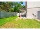 View of the backyard with green grass, a patio, and a balcony above at 1011 S Moody Ave # 11, Tampa, FL 33629