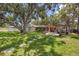 Large backyard offers mature trees, a lush lawn, and an inviting outdoor living space at 10730 52Nd N Ave, St Petersburg, FL 33708