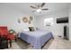 Cozy bedroom with a queen-size bed, ceiling fan, and a mounted television at 10730 52Nd N Ave, St Petersburg, FL 33708