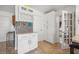 Kitchen area boasts stylish wine wrack, quartz countertop, and mosaic tile backsplash at 10730 52Nd N Ave, St Petersburg, FL 33708