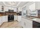 White kitchen cabinets, quartz countertops, tile backsplash, and stainless steel appliances at 10730 52Nd N Ave, St Petersburg, FL 33708