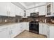 Bright kitchen with white cabinets, stainless appliances, and quartz countertops at 10730 52Nd N Ave, St Petersburg, FL 33708