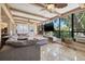 Bright living room featuring large windows, tile floors, a comfortable sofa and a decorative accent wall at 10730 52Nd N Ave, St Petersburg, FL 33708