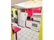 Kitchen featuring white appliances, red countertops, and a skylight, adjoining dining area at 10800 Us Highway 19 N # 143, Pinellas Park, FL 33782