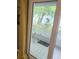 Looking from sliding glass door to outside patio with tiled floor and lush green foliage at 10800 Us Highway 19 N # 143, Pinellas Park, FL 33782