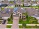 Aerial view of a beautiful home with solar panels, landscaping, and a paved driveway at 11035 Sage Canyon Dr, Riverview, FL 33578
