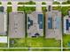 A detailed aerial view of roofs with solar panels, surrounded by green lawns and neighborhood streets at 11035 Sage Canyon Dr, Riverview, FL 33578