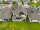 A rear aerial view showing solar panels and a covered patio, nestled among well-kept lawns and neighboring homes at 11035 Sage Canyon Dr, Riverview, FL 33578