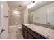 Well-lit bathroom with granite countertop, shower over tub, and tile flooring at 11035 Sage Canyon Dr, Riverview, FL 33578
