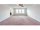 Bright bedroom features three windows, neutral carpeting, and ceiling fan with light fixture at 11035 Sage Canyon Dr, Riverview, FL 33578