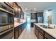 Well-equipped kitchen with stainless steel appliances, dark wood cabinets, tile backsplash, and a kitchen island at 11035 Sage Canyon Dr, Riverview, FL 33578