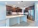 Modern kitchen featuring dark wood cabinetry, stainless steel appliances, a large island, and recessed lighting at 11035 Sage Canyon Dr, Riverview, FL 33578