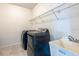Functional laundry room with washer, dryer, utility sink, and wire shelving at 11035 Sage Canyon Dr, Riverview, FL 33578