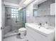 This bathroom offers a glass shower, modern vanity with white sink, and mosaic tile flooring at 11301 80Th Ave, Seminole, FL 33772
