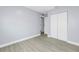 A spacious bedroom with new vinyl flooring and a walk-in closet with a view to the bathroom and kitchen at 11301 80Th Ave, Seminole, FL 33772