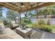 Relaxing outdoor patio area with comfortable seating, a ceiling fan, and lush landscaping at 11301 80Th Ave, Seminole, FL 33772