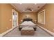 Spacious bedroom with plush carpet, ottoman, and natural light from the windows at 11430 Trotting Down Dr, Odessa, FL 33556