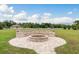 An inviting outdoor fire pit with seating surrounded by a spacious yard and a white fence at 11430 Trotting Down Dr, Odessa, FL 33556