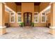 Elegant front entrance of a custom home with a double door entry, brick flooring, and mature landscaping at 11430 Trotting Down Dr, Odessa, FL 33556