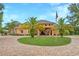Beautiful custom home featuring lush landscaping, circular driveway and grand entrance with American flag at 11430 Trotting Down Dr, Odessa, FL 33556
