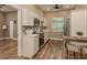 Kitchen featuring stainless steel appliances, wood-look floors, white cabinets, and sink with window at 11430 Trotting Down Dr, Odessa, FL 33556