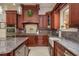 Chef's kitchen with granite countertops, custom cabinetry, and modern stainless steel appliances at 11430 Trotting Down Dr, Odessa, FL 33556