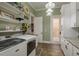 Well-lit laundry room featuring white cabinets, stainless sink, modern washer and dryer at 11430 Trotting Down Dr, Odessa, FL 33556