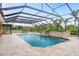 Inground pool with screened in enclosure and stone wall features at 11430 Trotting Down Dr, Odessa, FL 33556