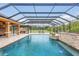 A screened-in pool with an outdoor kitchen and lounge chairs offers a luxurious outdoor space at 11430 Trotting Down Dr, Odessa, FL 33556