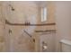 Walk-in shower with tan tile surround, hand rails and shower seat at 11430 Trotting Down Dr, Odessa, FL 33556