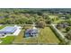 Expansive property featuring a pool, lush lawn, and a large outbuilding against a backdrop of dense trees at 12637 Tyler Run Ave, Odessa, FL 33556