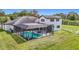 Aerial view showcasing a screened pool enclosure and ample green space at 12637 Tyler Run Ave, Odessa, FL 33556