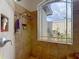 Shower featuring tiled walls, a shower head, and a window letting in natural light at 12637 Tyler Run Ave, Odessa, FL 33556
