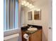 Compact bathroom featuring a granite countertop vanity, a toilet, and a well-lit mirror at 12637 Tyler Run Ave, Odessa, FL 33556