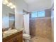 Bathroom features a tile shower, granite vanity and window with a view at 12637 Tyler Run Ave, Odessa, FL 33556